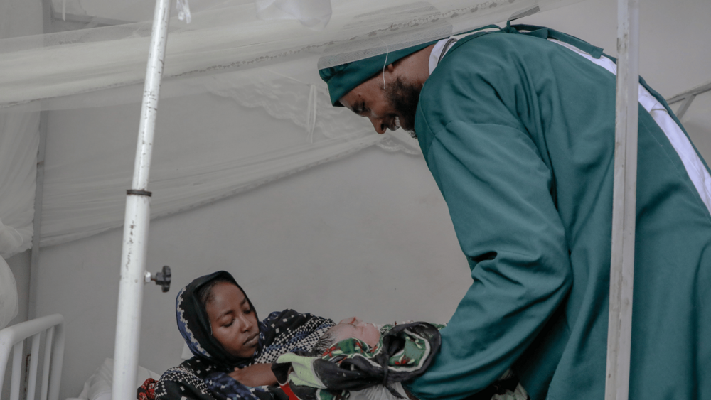Wubayehu Shasho gently hands the newborn to the mother, marking the start of a new chapter filled with hope and love.