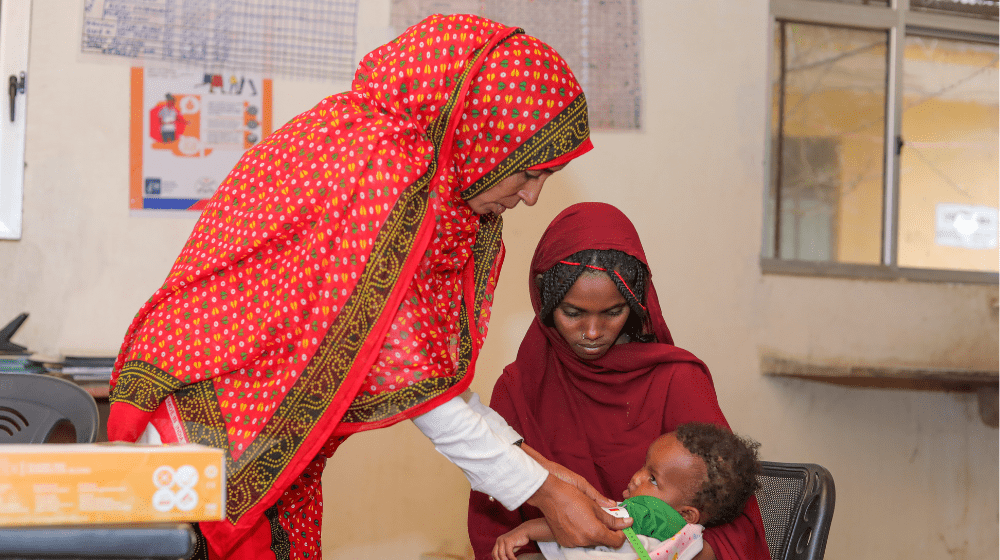 Zeyneb's child getting a check-up service at a health center 